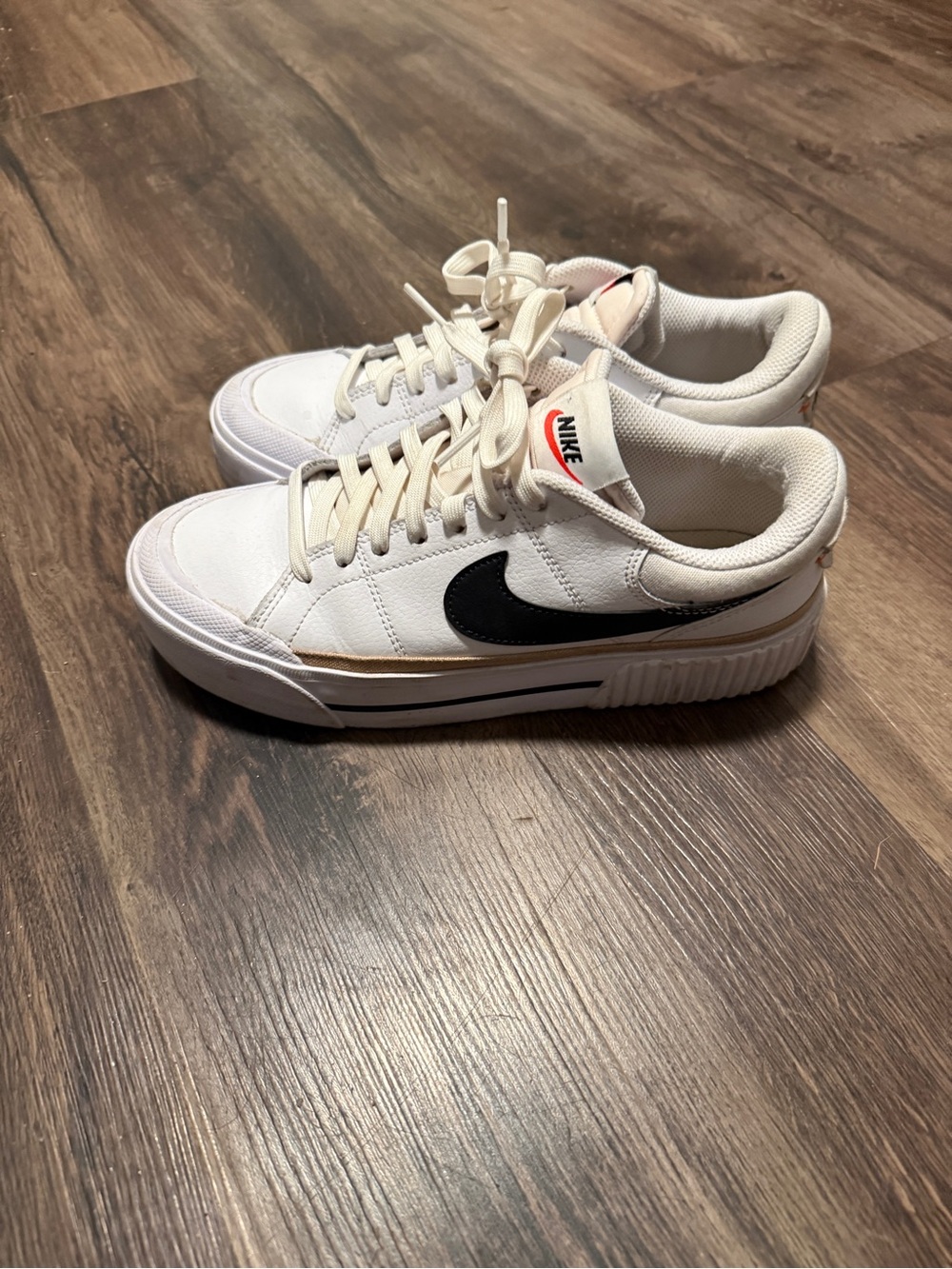 Nike Women's White Sneakers with Black Swoosh and Gold Trim